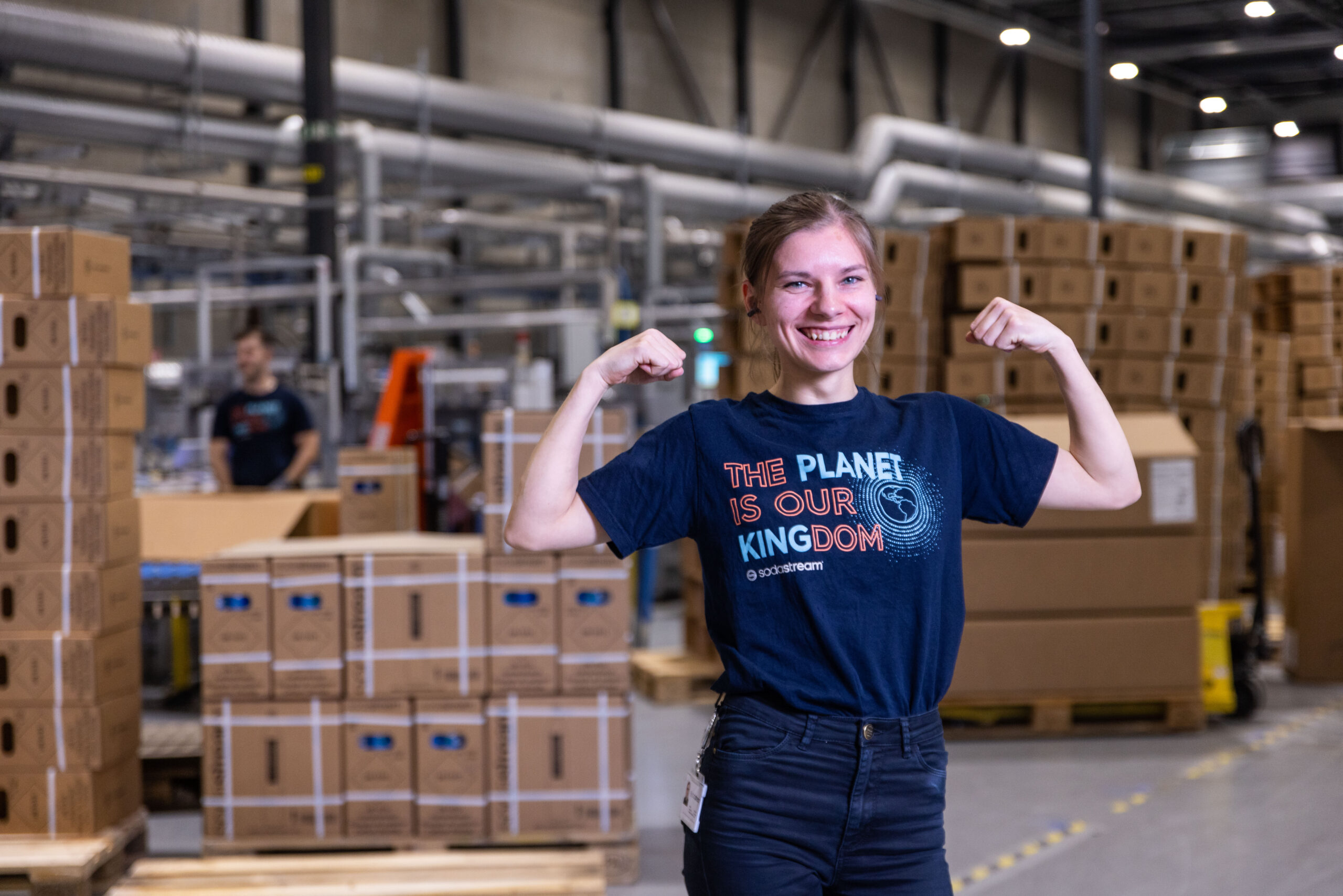 Vrolijke vrouw spant haar spierballen aan in een magazijn