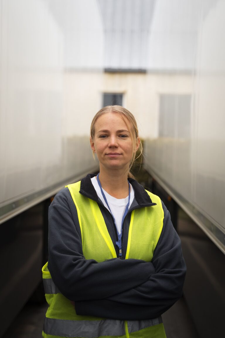 front-view-professional-female-driver-with-vest-min